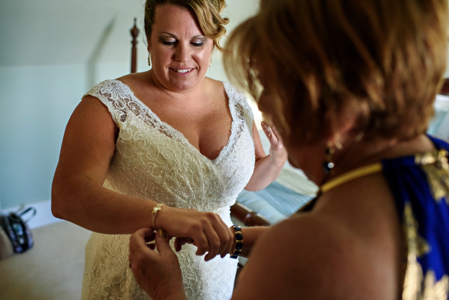 A mother helping her daughter put on jewelry on her wedding day.